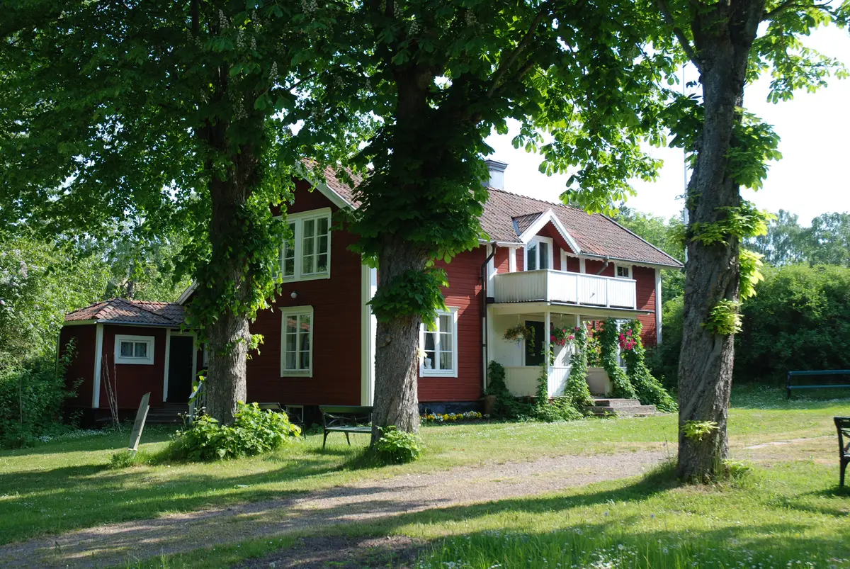 Albert Engströms museum i ett falurött hus omgivet av stora träd i Grisslehamn